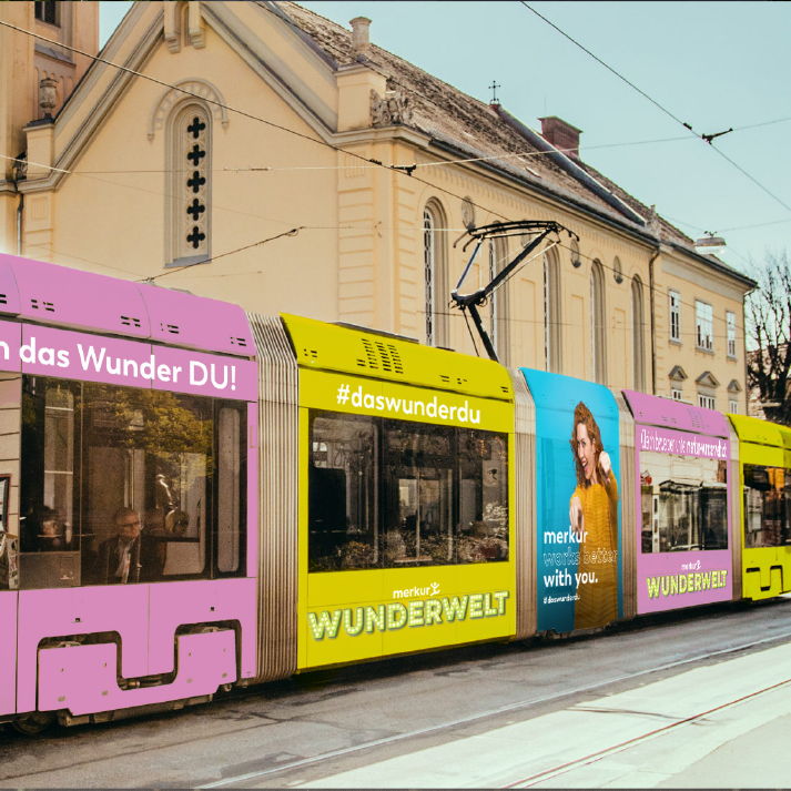 Straßenbahn mit Beklebung der Kampagne für die Merkur Versicherung