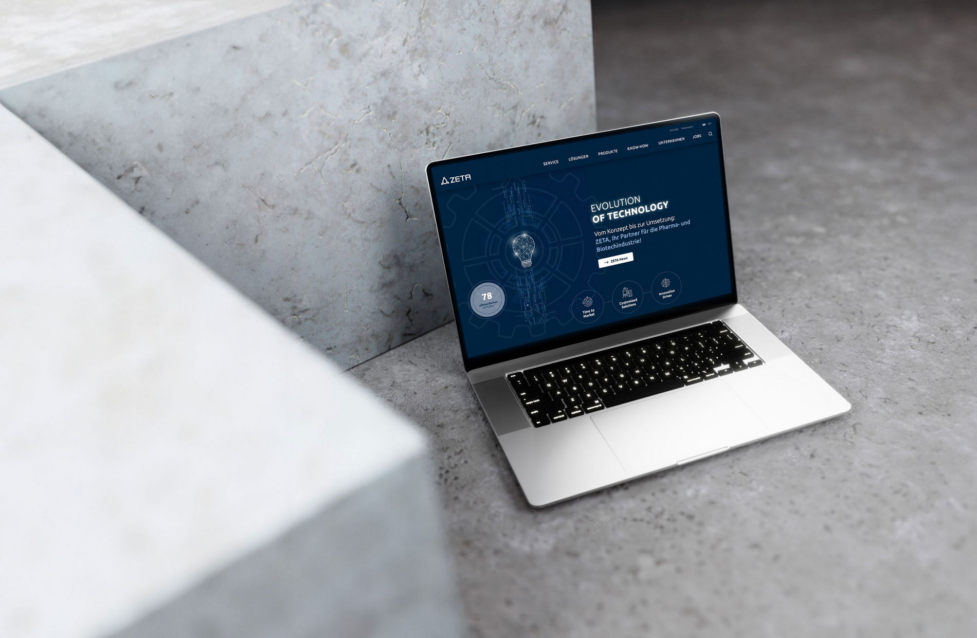 Laptop mit geöffneter Zeta Website vor industriellem Hintergrund