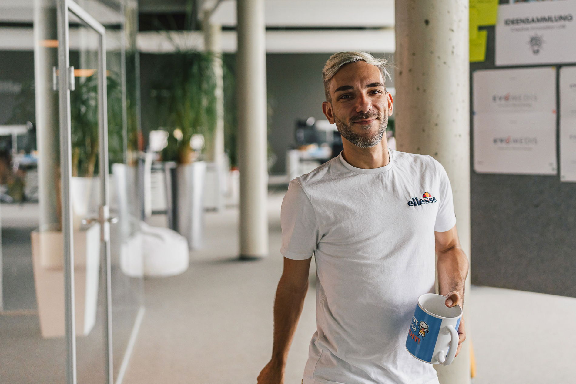 Mathias mit seiner großen Kaffeetasse auf dem Weg zum Nachschub