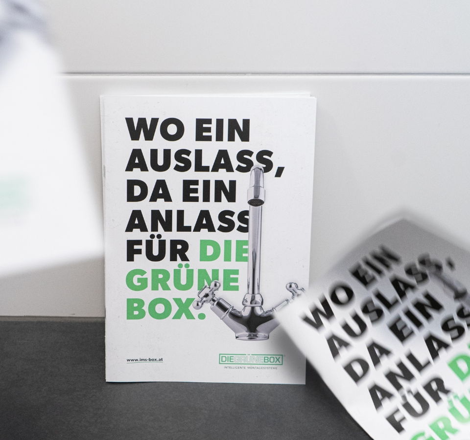 Visitenkarten von IMS Die Grüne Box vor weißen Fliesen